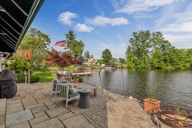 view of patio featuring a water view, a grill, and a fire pit