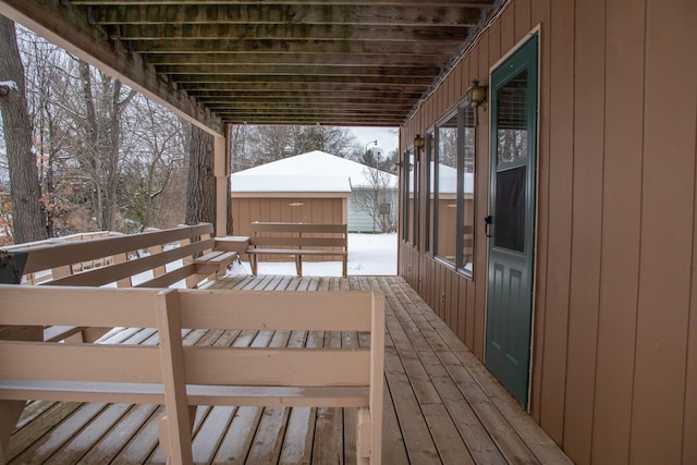 snow covered deck with a storage shed