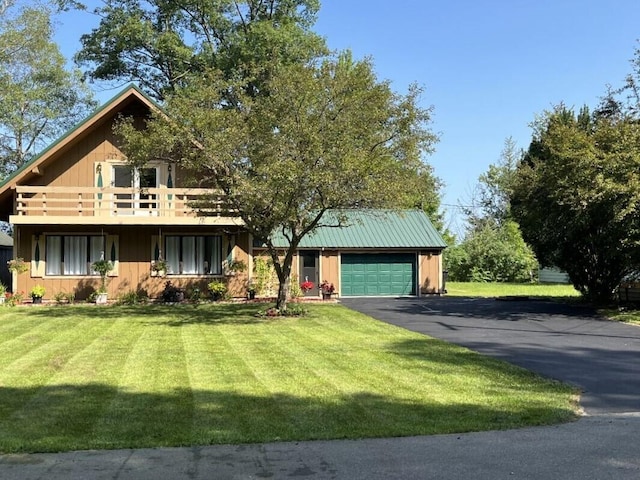 view of front of house featuring a garage, a front lawn, and a balcony