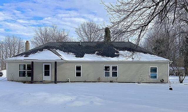 view of snow covered back of property