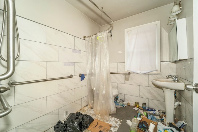 bathroom featuring a shower with curtain, toilet, and tile walls