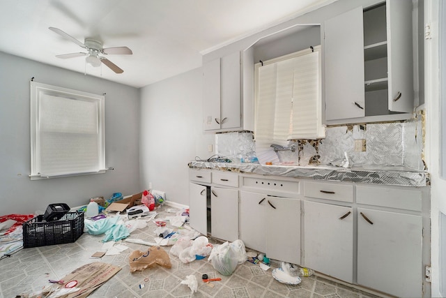 kitchen featuring backsplash, white cabinets, and ceiling fan