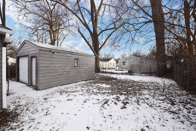 yard covered in snow with a garage and an outdoor structure