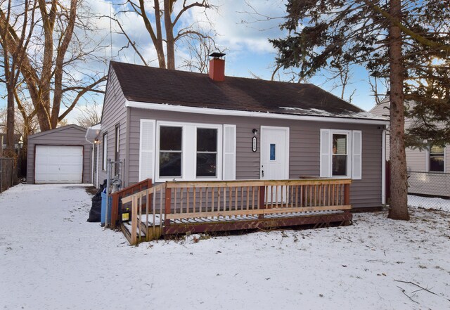 bungalow-style home featuring a garage and an outbuilding