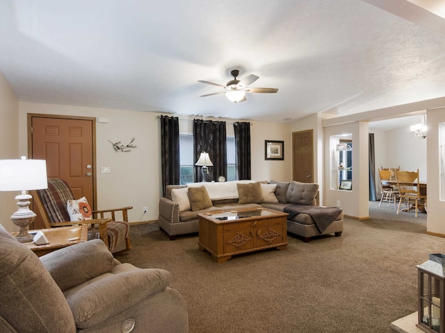 living room featuring ceiling fan with notable chandelier and carpet flooring