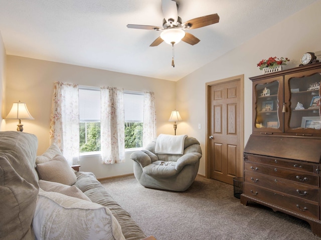 living area with ceiling fan, carpet, and lofted ceiling