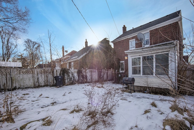 view of snow covered rear of property