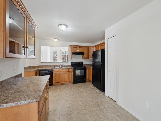 kitchen with a sink, glass insert cabinets, brown cabinetry, under cabinet range hood, and black appliances