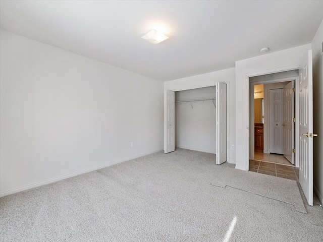 unfurnished bedroom featuring a closet, baseboards, and light carpet