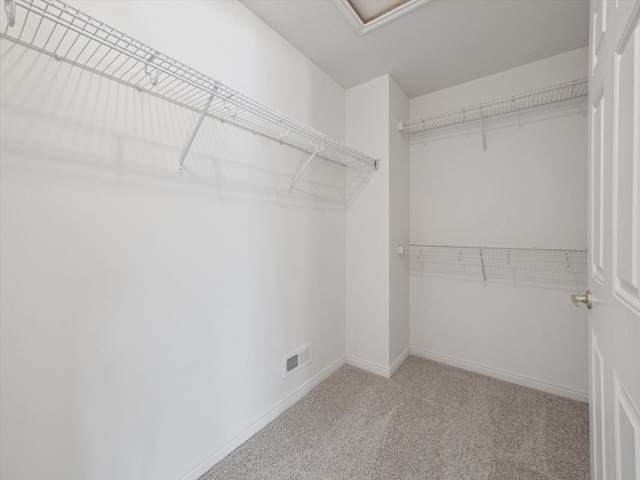 spacious closet featuring attic access, visible vents, and carpet flooring