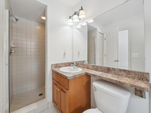 bathroom featuring toilet, a stall shower, and vanity