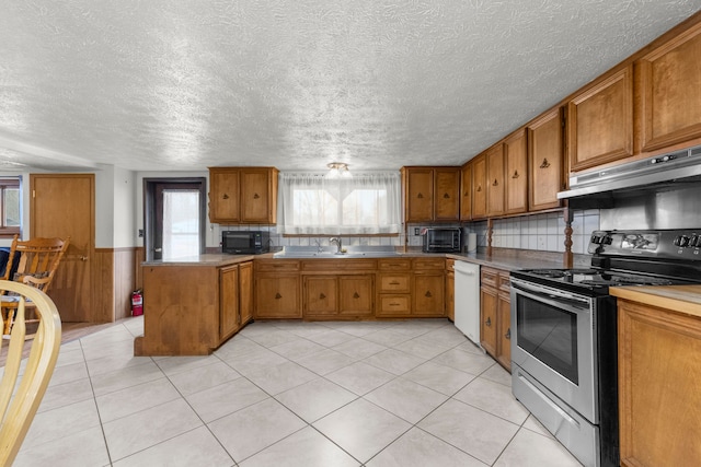 42891 Bemis Rd, Sumpter, MI 48111 - kitchen featuring light tile patterned floors, dishwasher, kitchen peninsula, and electric range