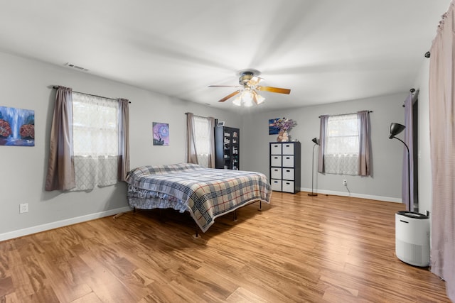 42891 Bemis Rd, Sumpter, MI 48111 - bedroom with ceiling fan, multiple windows, and light hardwood / wood-style floors