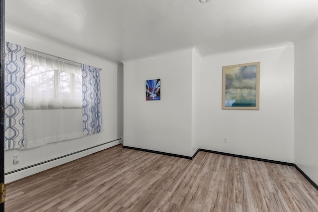 42891 Bemis Rd, Sumpter, MI 48111 - spare room featuring baseboard heating and light hardwood / wood-style floors