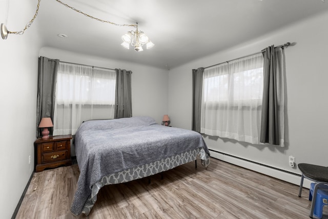 42891 Bemis Rd, Sumpter, MI 48111 - bedroom with an inviting chandelier, baseboard heating, and hardwood / wood-style flooring