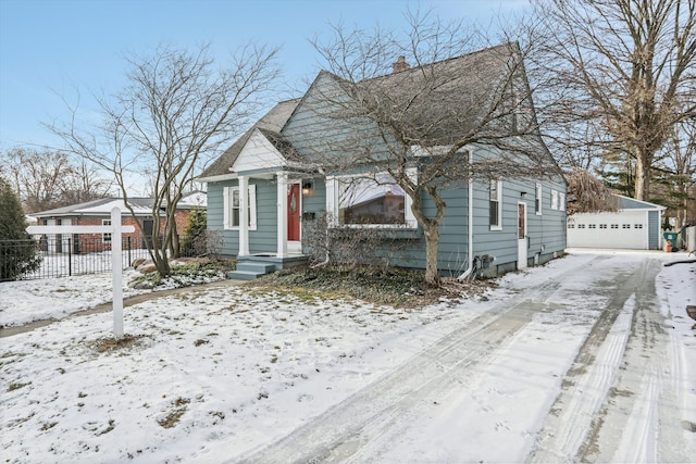 bungalow-style home featuring a garage and an outbuilding