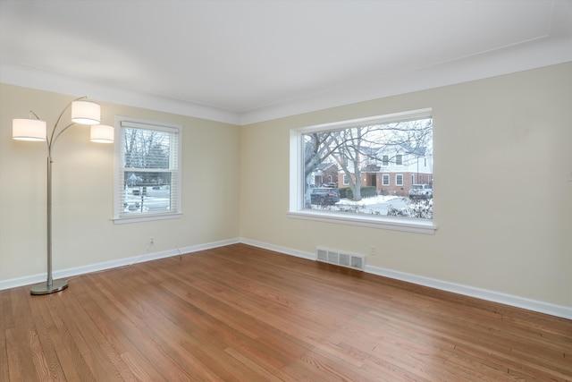 empty room with crown molding and hardwood / wood-style flooring