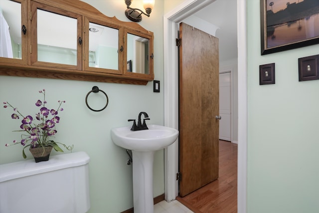 bathroom featuring toilet, hardwood / wood-style floors, and sink