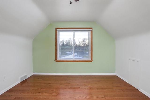 bonus room with lofted ceiling and light wood-type flooring