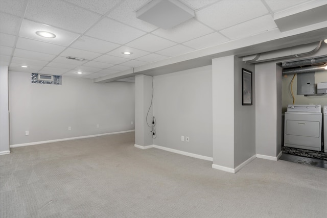 basement featuring light carpet, a paneled ceiling, electric panel, and washing machine and clothes dryer