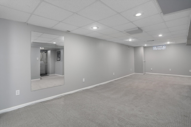 basement featuring a paneled ceiling and carpet