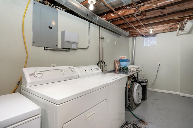 clothes washing area featuring electric panel and washing machine and dryer