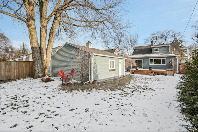 snow covered rear of property featuring a deck