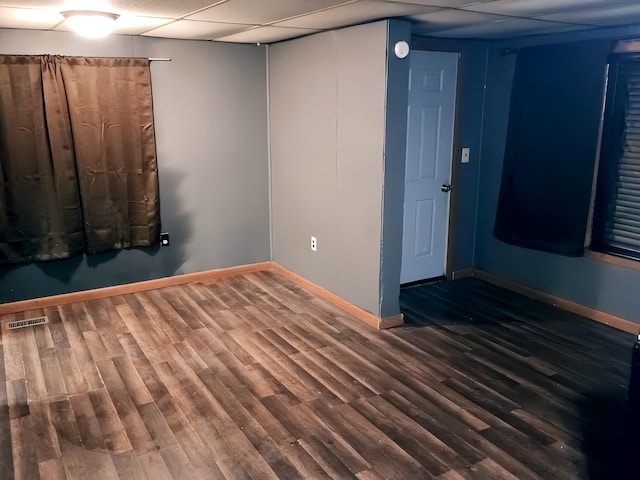 unfurnished room featuring a paneled ceiling and dark hardwood / wood-style flooring