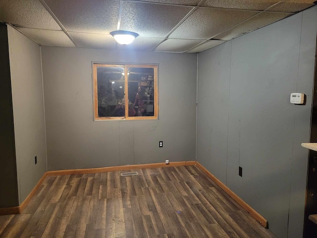 unfurnished room with dark wood-type flooring and a drop ceiling