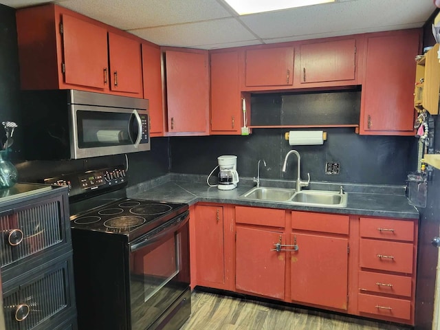 kitchen featuring black range with electric stovetop, sink, a paneled ceiling, and light wood-type flooring