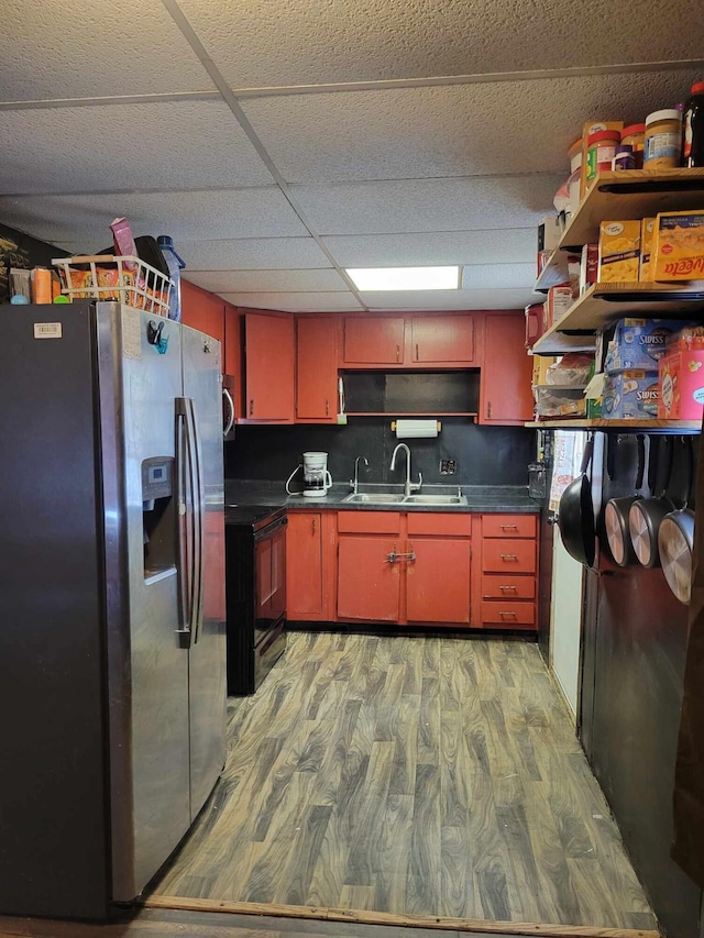 kitchen featuring black electric range oven, sink, light hardwood / wood-style flooring, a paneled ceiling, and stainless steel fridge with ice dispenser