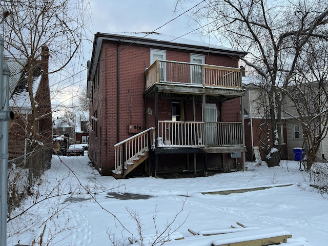 snow covered property with a balcony