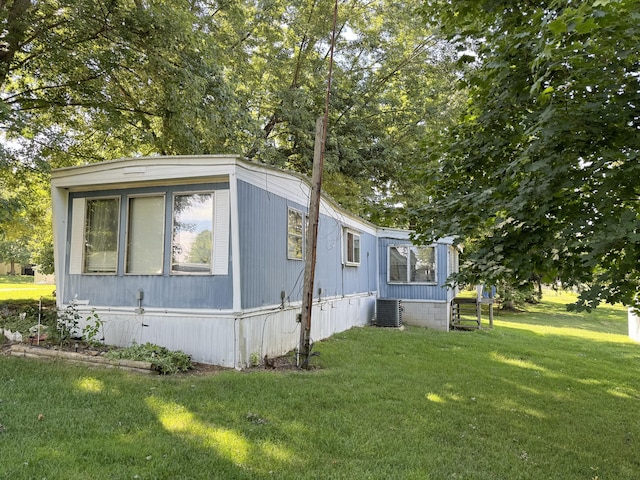 view of home's exterior with central air condition unit and a lawn