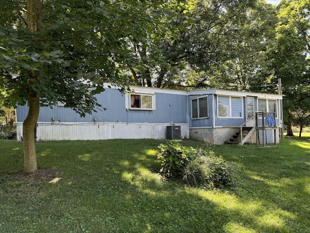 exterior space featuring central AC unit and a front lawn