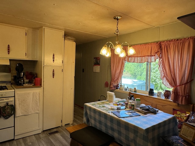 dining space with hardwood / wood-style flooring and a chandelier