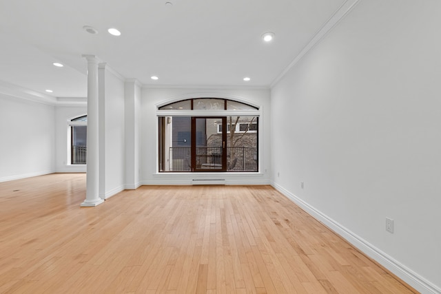 interior space featuring a baseboard heating unit, crown molding, light hardwood / wood-style flooring, and decorative columns