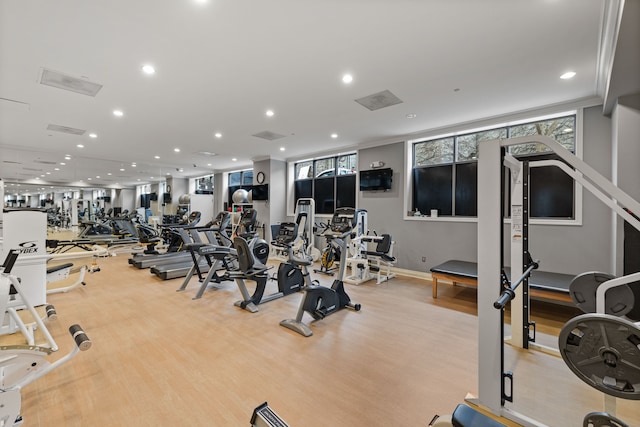 gym with light hardwood / wood-style flooring and ornamental molding