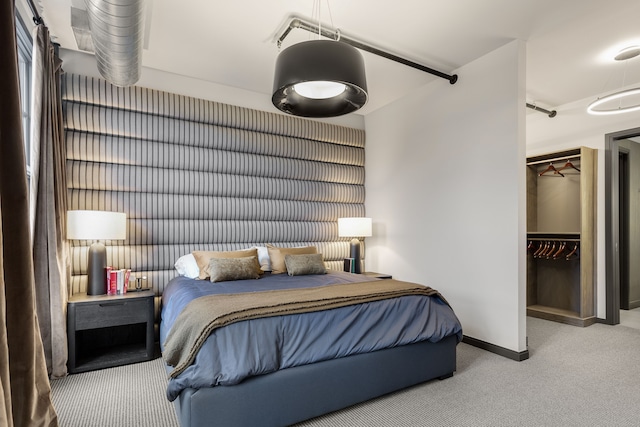 bedroom featuring a closet, light colored carpet, and a spacious closet