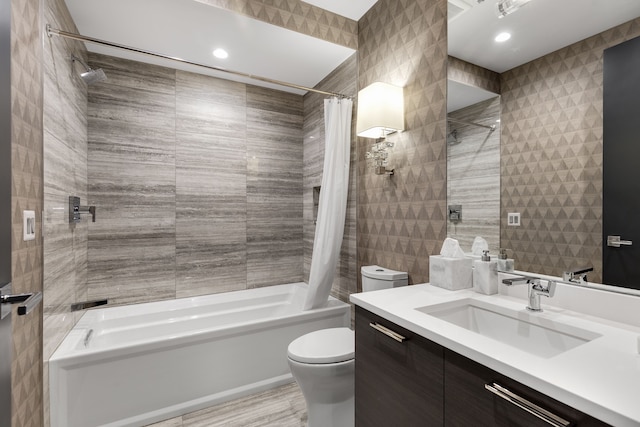 full bathroom with tile walls, toilet, vanity, and shower / bathtub combination with curtain