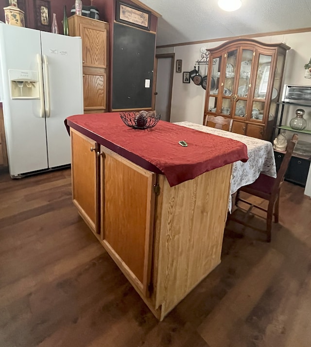 kitchen with a kitchen island, crown molding, white fridge with ice dispenser, and dark hardwood / wood-style floors