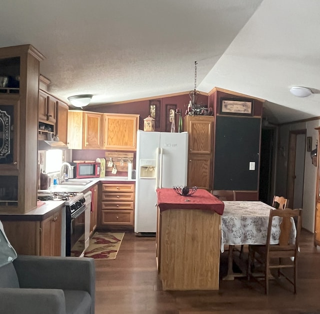 kitchen featuring range with gas cooktop, lofted ceiling, a kitchen island, dark wood-type flooring, and white fridge with ice dispenser