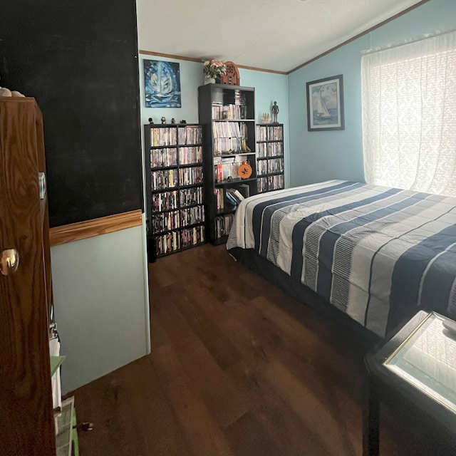 bedroom featuring dark hardwood / wood-style floors, ornamental molding, and lofted ceiling