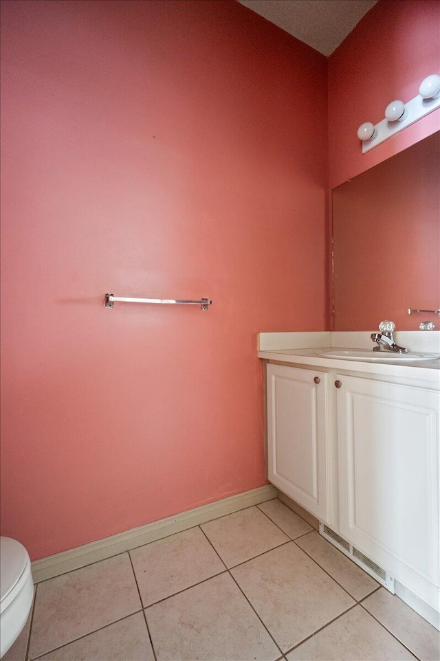 bathroom featuring toilet, baseboards, vanity, and tile patterned floors