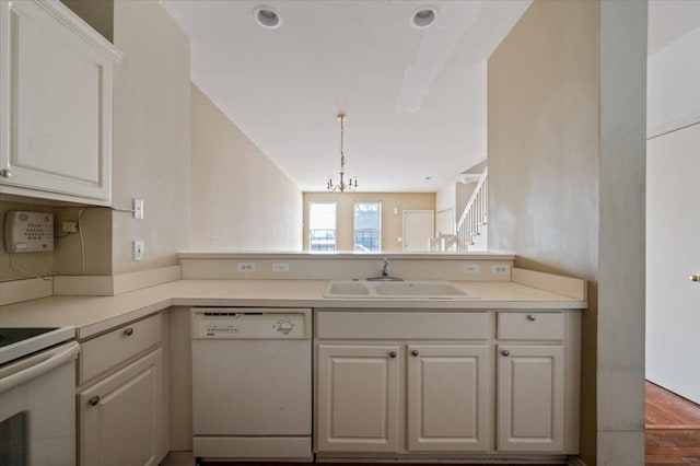 kitchen with white appliances, light countertops, a sink, and white cabinets