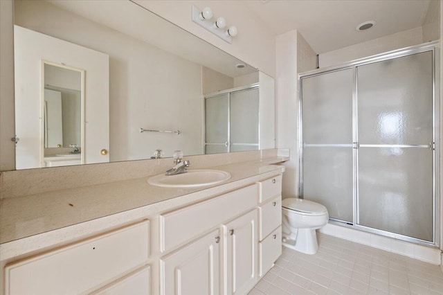 bathroom featuring a stall shower, tile patterned flooring, vanity, and toilet