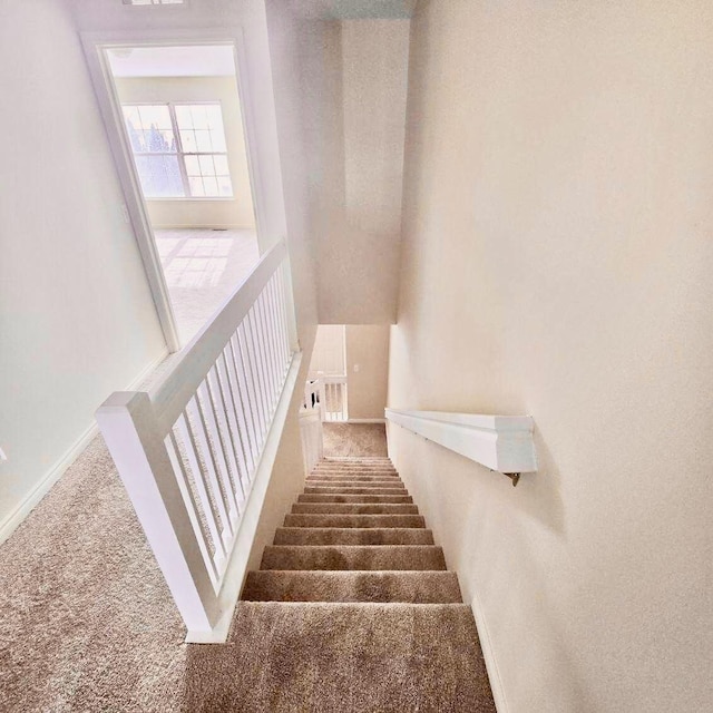 stairway featuring carpet floors, visible vents, and baseboards