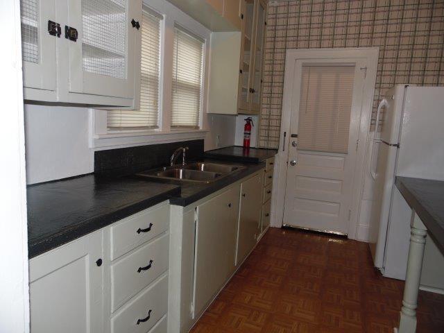 kitchen featuring sink, white cabinetry, dark parquet flooring, and white refrigerator