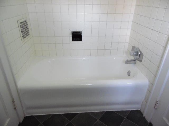 bathroom with a bath and tile patterned floors