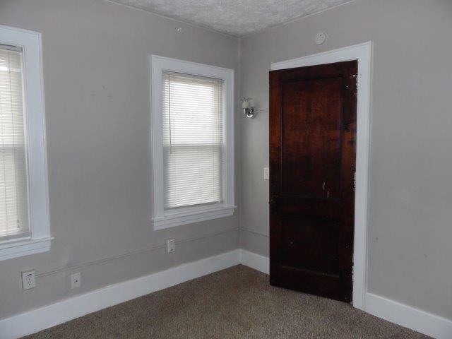 unfurnished room featuring a textured ceiling and carpet floors