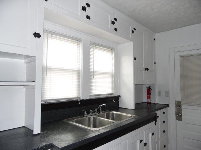 kitchen featuring sink, a textured ceiling, and white cabinets